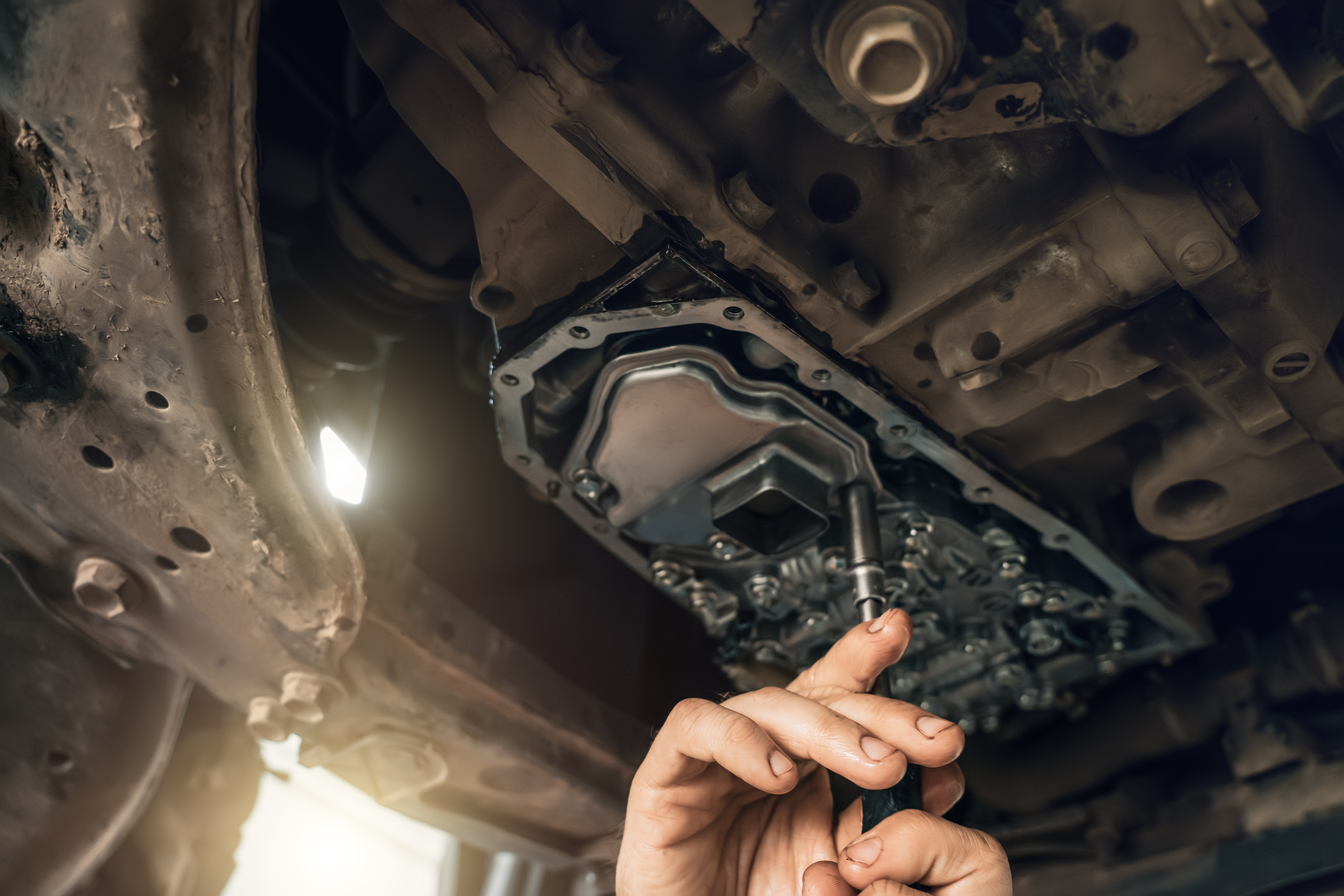 Technician diagnosing a transmission under a vehicle